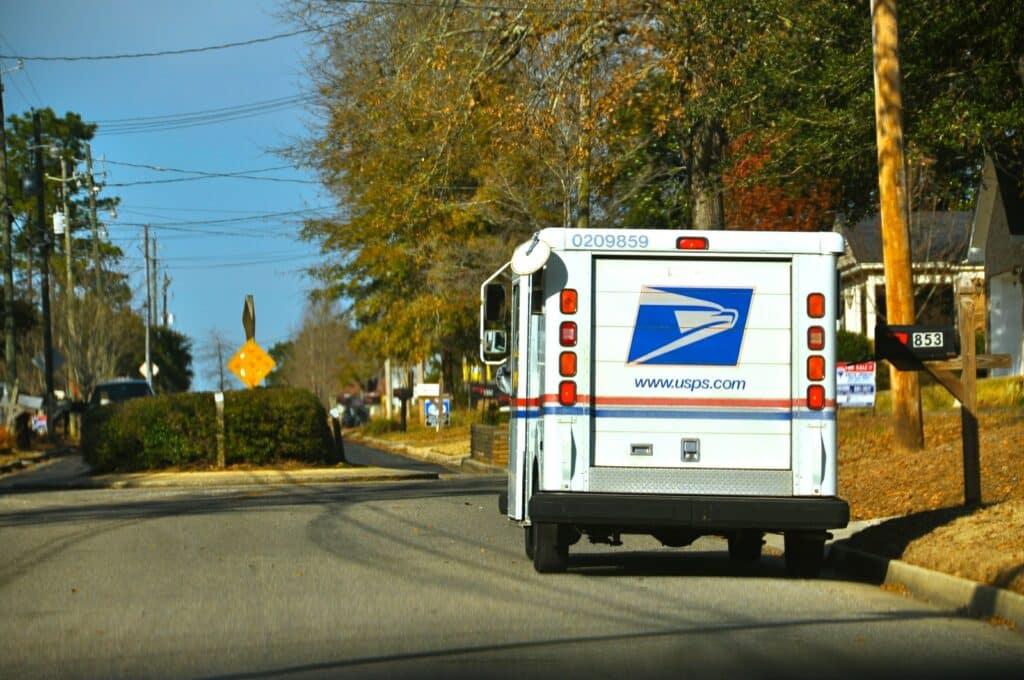 USPS truck delivering mail on the side of the road