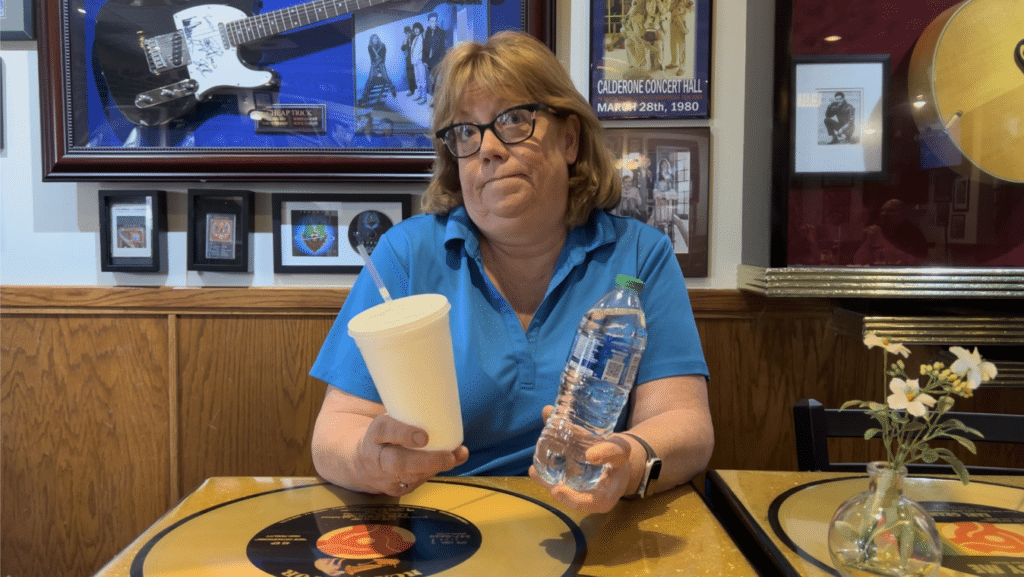 Augustino's Rock & Roll Deli Cathy Morelli with sytrofoam cup and water bottle