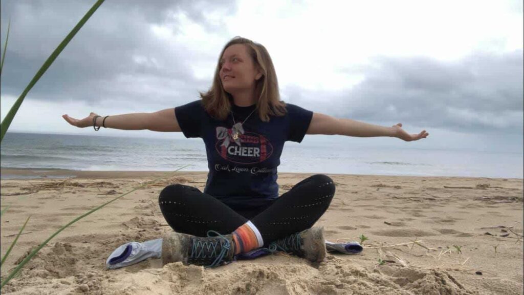 Amanda on the beach with her hands stretched out. Knowing that she has beat depression.