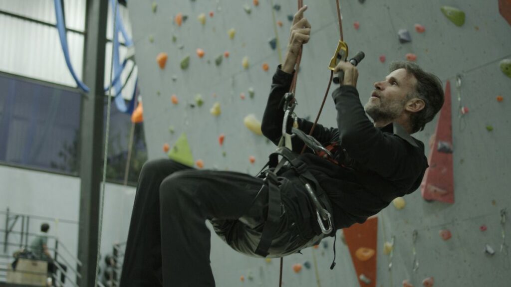 Adaptive athlete Sebastián Carrasco climbing rugged terrain in Beyond The Fall documentary film.
