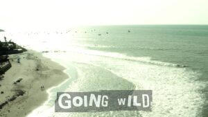 Aerial view of the Pacific coast at Máncora with Going Wild music-video title