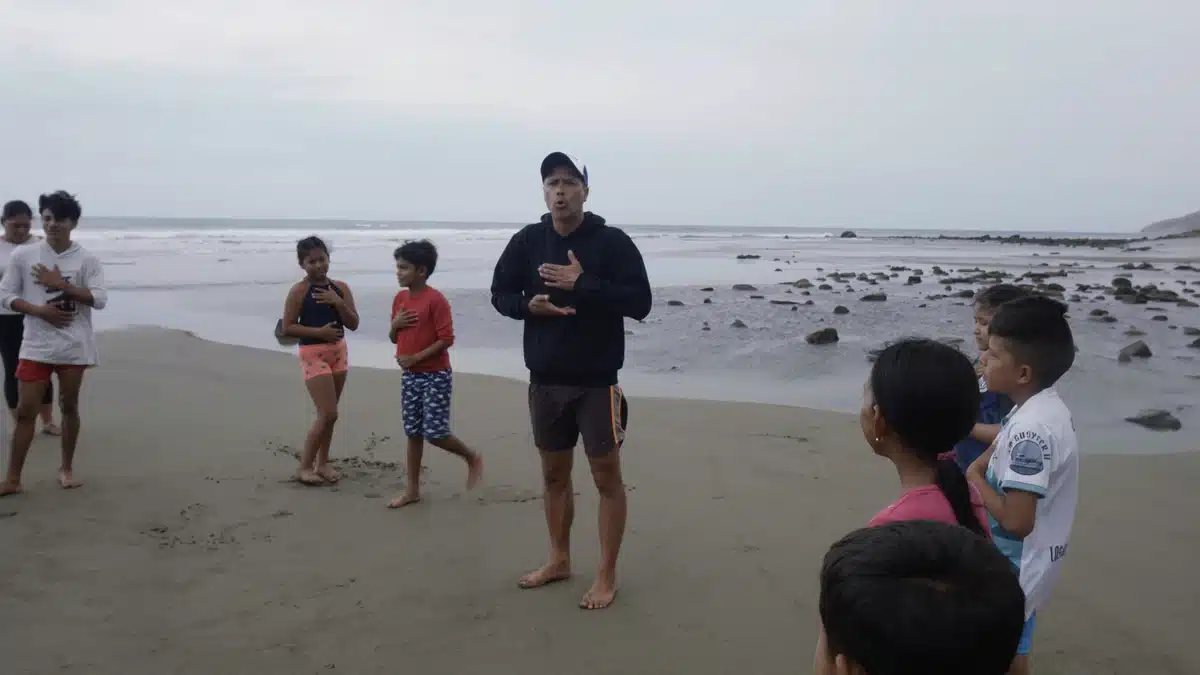 Sebastián Hernández leads children through a breathing exercise on the beach in Ligüiqui, Ecuador.
